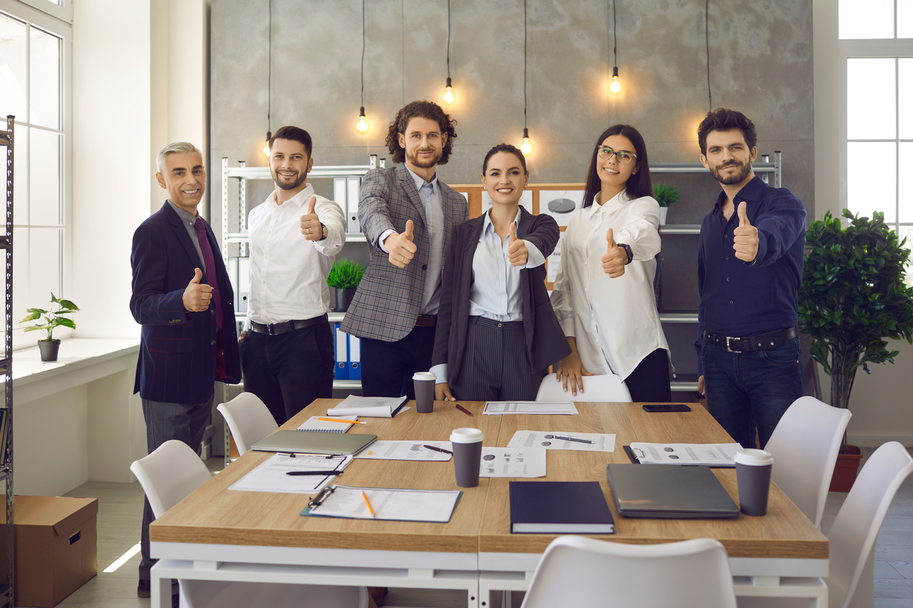 Team of Happy Employees Giving Thumbs up Standing in Office after Corporate Meeting